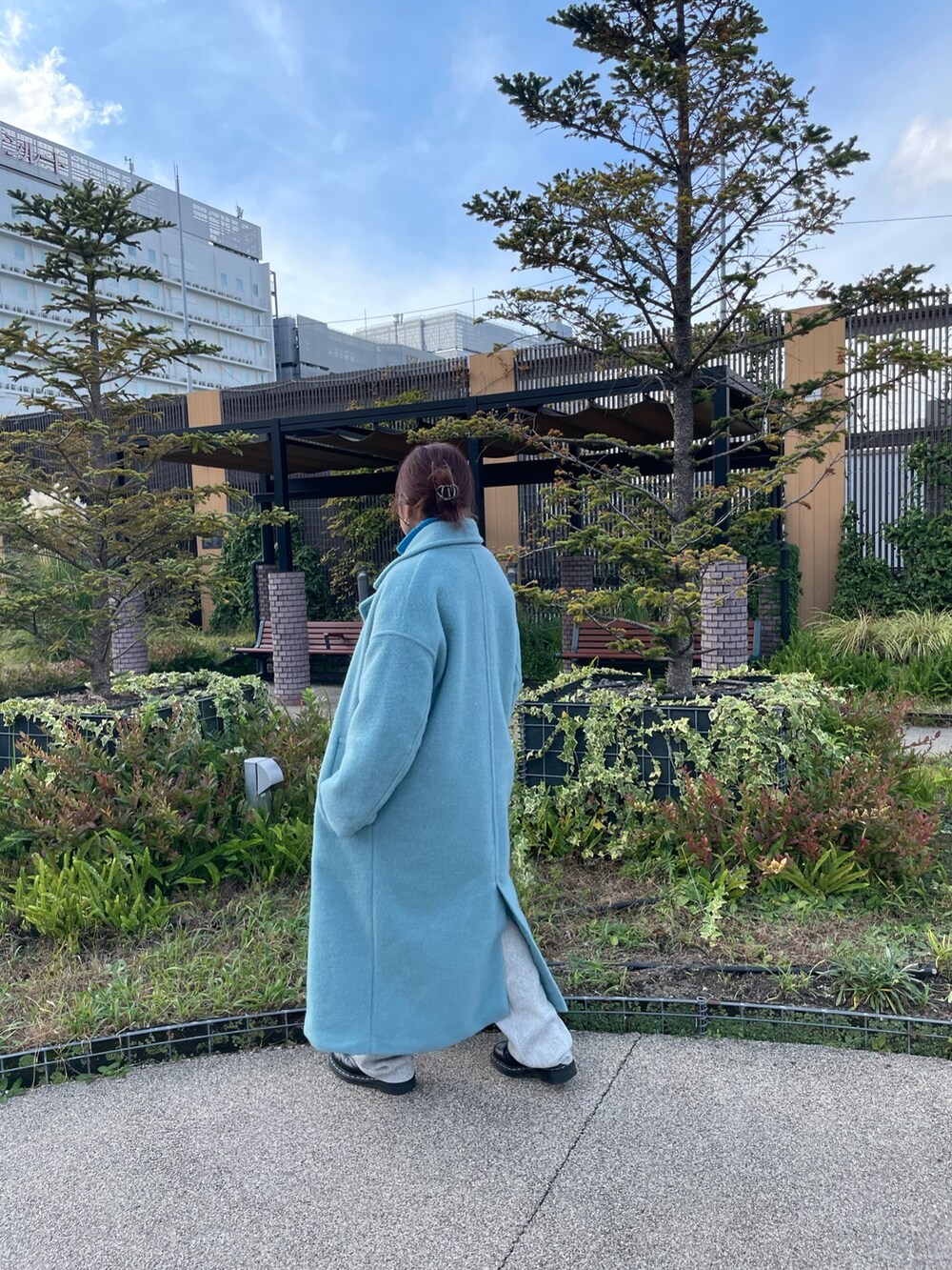 ブルー系のチェスターコート、ブルー系のニット/セーター、グレー系のその他パンツを着用したレディースの冬コーディネートの2枚目の写真