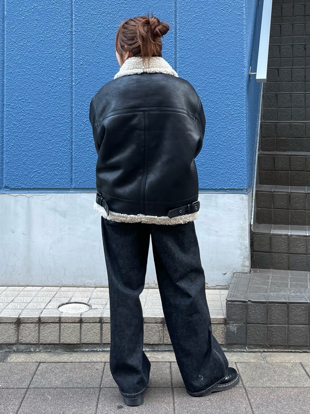 ブラック系のブルゾン、ブラック系のデニムパンツを着用したレディースの秋コーディネートの3枚目の写真