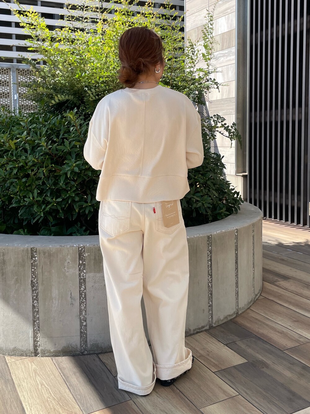 ホワイト系のTシャツ/カットソー、ホワイト系のデニムパンツ、ブラック系のパンプスを着用したレディースの秋コーディネートの2枚目の写真