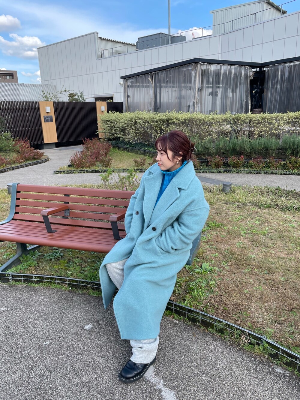 ブルー系のチェスターコート、ブルー系のニット/セーター、グレー系のその他パンツを着用したレディースの冬コーディネートの3枚目の写真