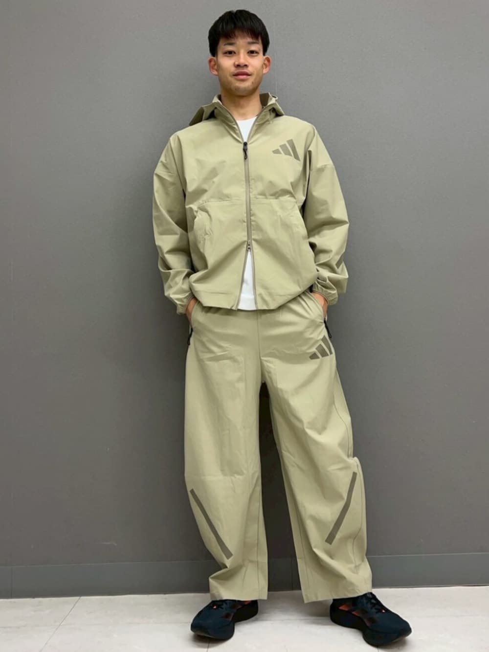 グレー系のシューズ、ホワイト系のTシャツ/カットソー、ブラウン系のジャージを着用したメンズの春コーディネートの2枚目の写真