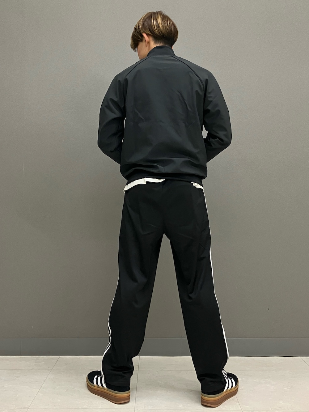 ホワイト系のトップス、ブラック系のジャージ、ブラック系のスウェットパンツを着用したメンズの冬コーディネートの4枚目の写真