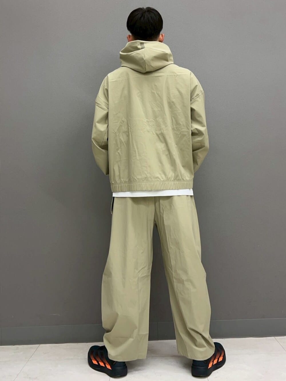 グレー系のシューズ、ホワイト系のTシャツ/カットソー、ブラウン系のジャージを着用したメンズの春コーディネートの4枚目の写真