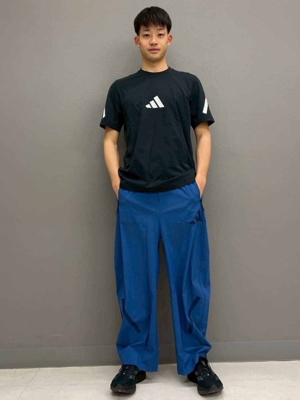 ブルー系のジャージ、ブルー系のその他パンツ、ブラック系のTシャツ/カットソーを着用したメンズの春コーディネートの3枚目の写真