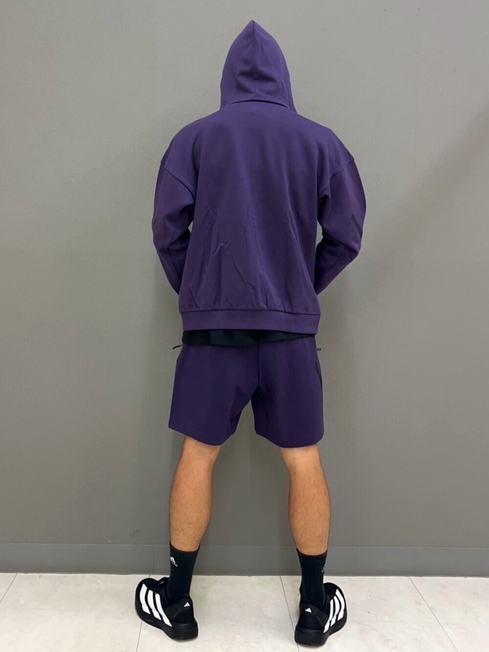 パープル系のパーカー、ブラック系のTシャツ/カットソー、パープル系のパンツを着用したメンズの秋コーディネートの4枚目の写真