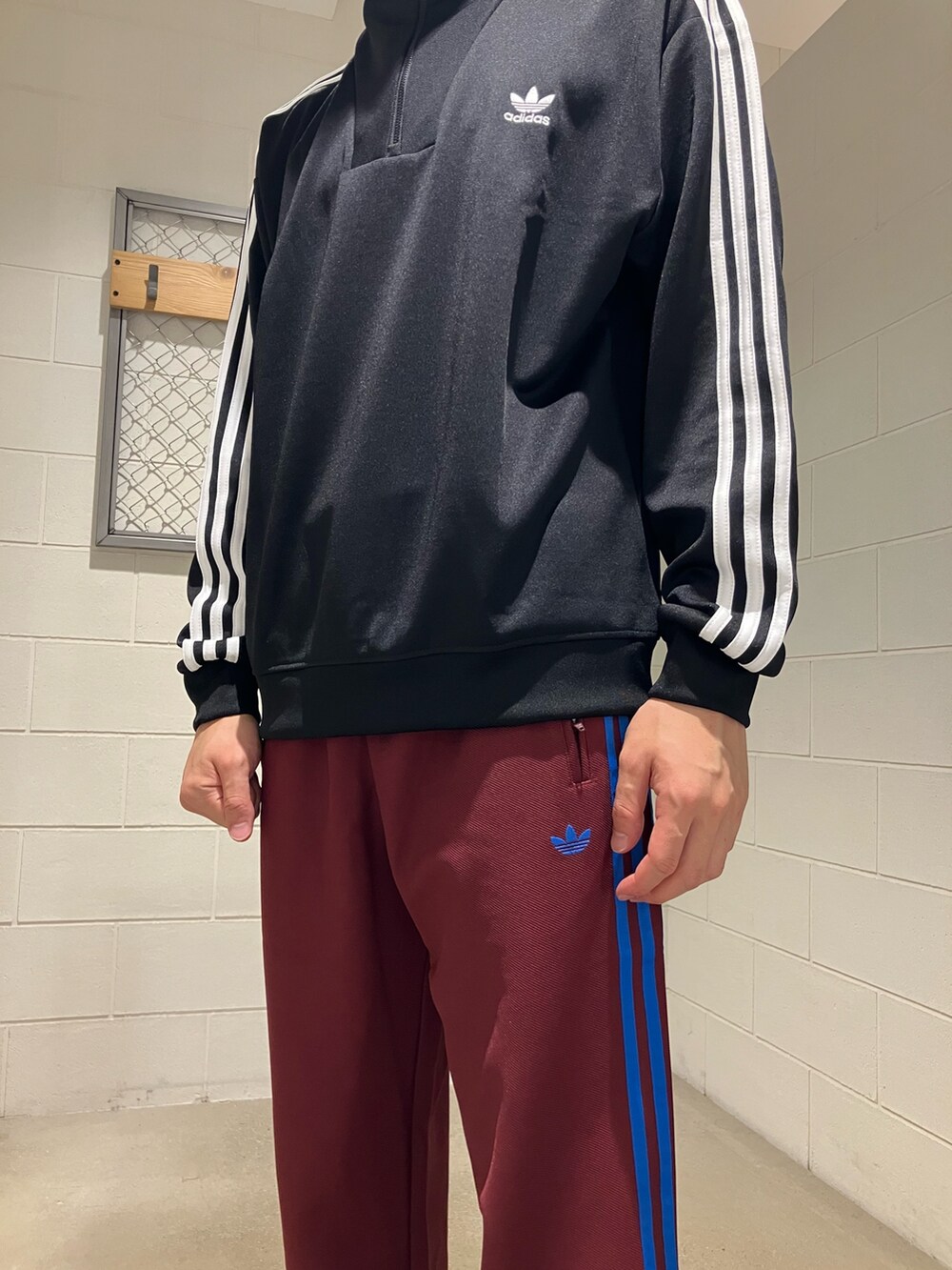 ブラック系のナイロンジャケット、レッド系のその他パンツ、レッド系のスニーカーを着用したメンズの秋コーディネートの2枚目の写真