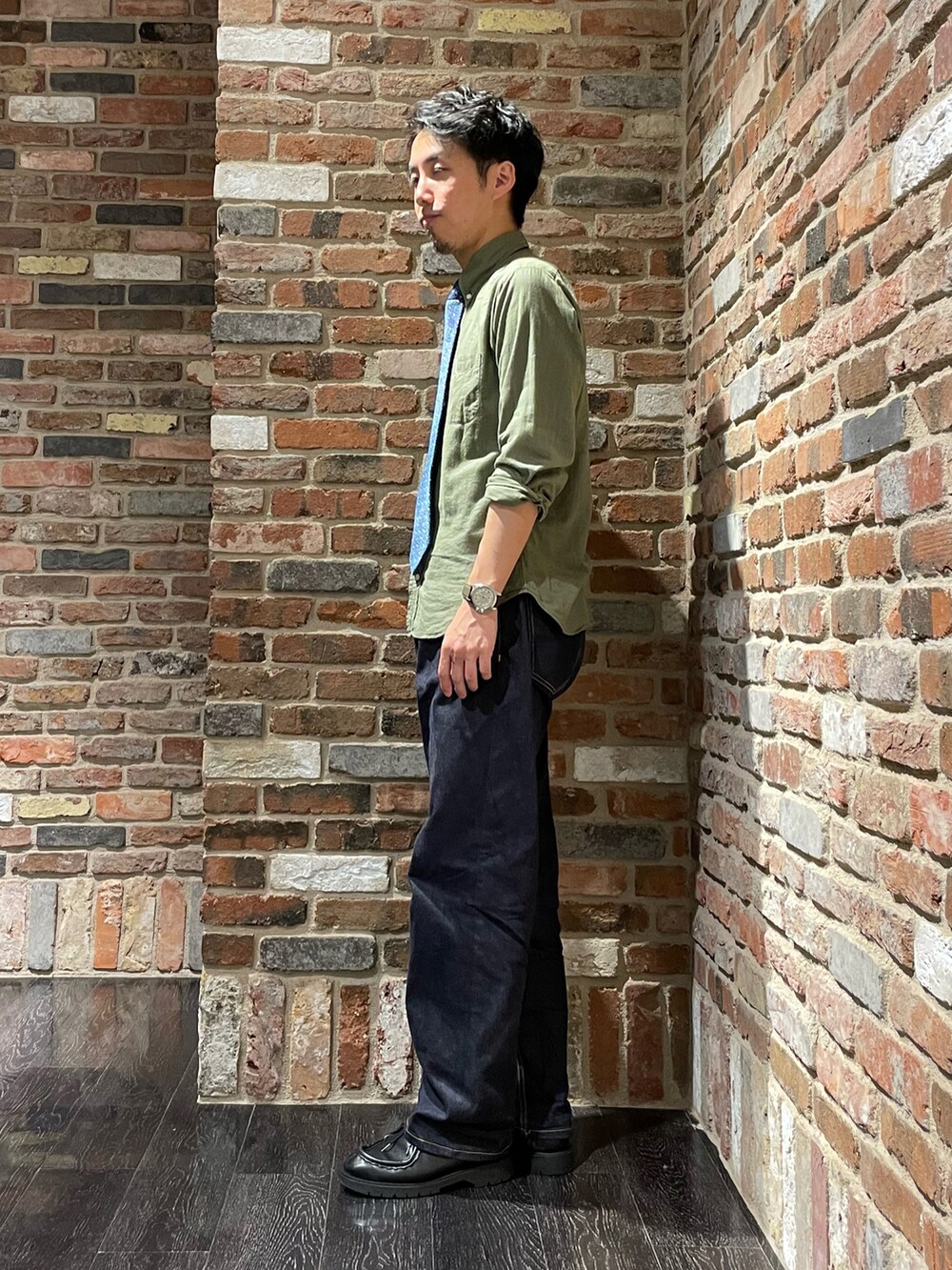 グリーン系のシャツ/ブラウス、ブルー系のネクタイ、ブルー系のデニムパンツを着用したメンズの夏コーディネートの2枚目の写真