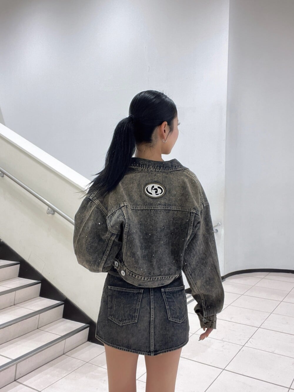 ブラック系のブーツ、ブラック系のTシャツ/カットソー、ブルー系のデニムジャケットを着用したレディースの秋コーディネートの5枚目の写真