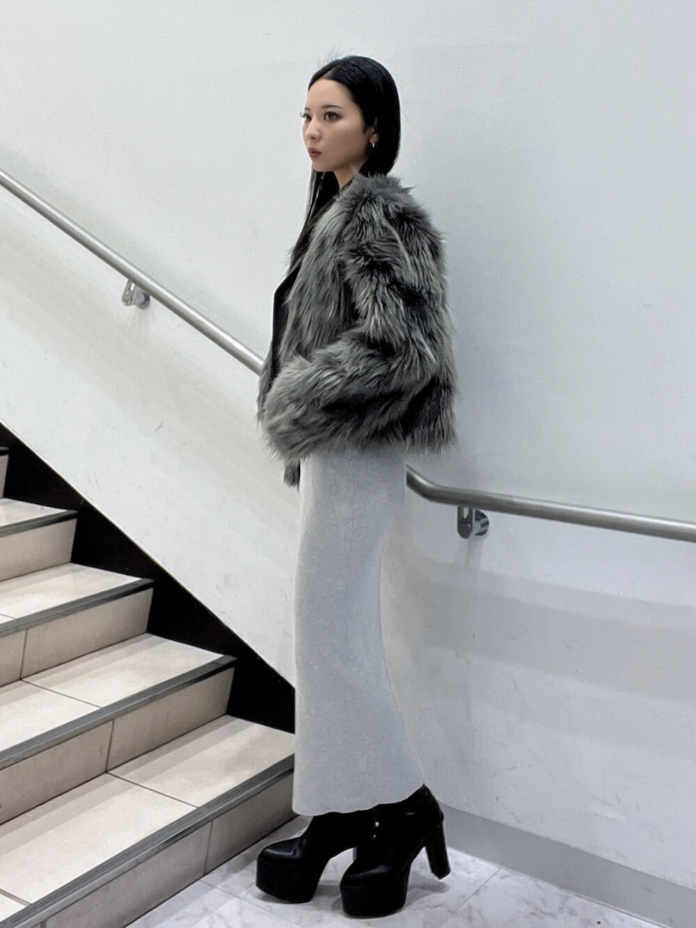 ブラック系のブーツ、グレー系のワンピース、グレー系のライダースジャケットを着用したレディースの冬コーディネートの3枚目の写真