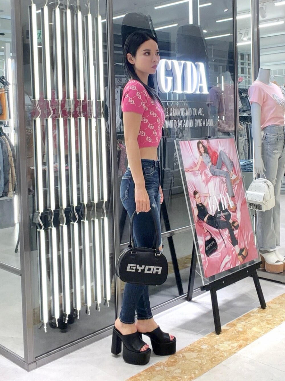 ブラック系のサンダル、ブルー系のデニムパンツ、ピンク系のニット/セーターを着用したレディースの夏コーディネートの3枚目の写真