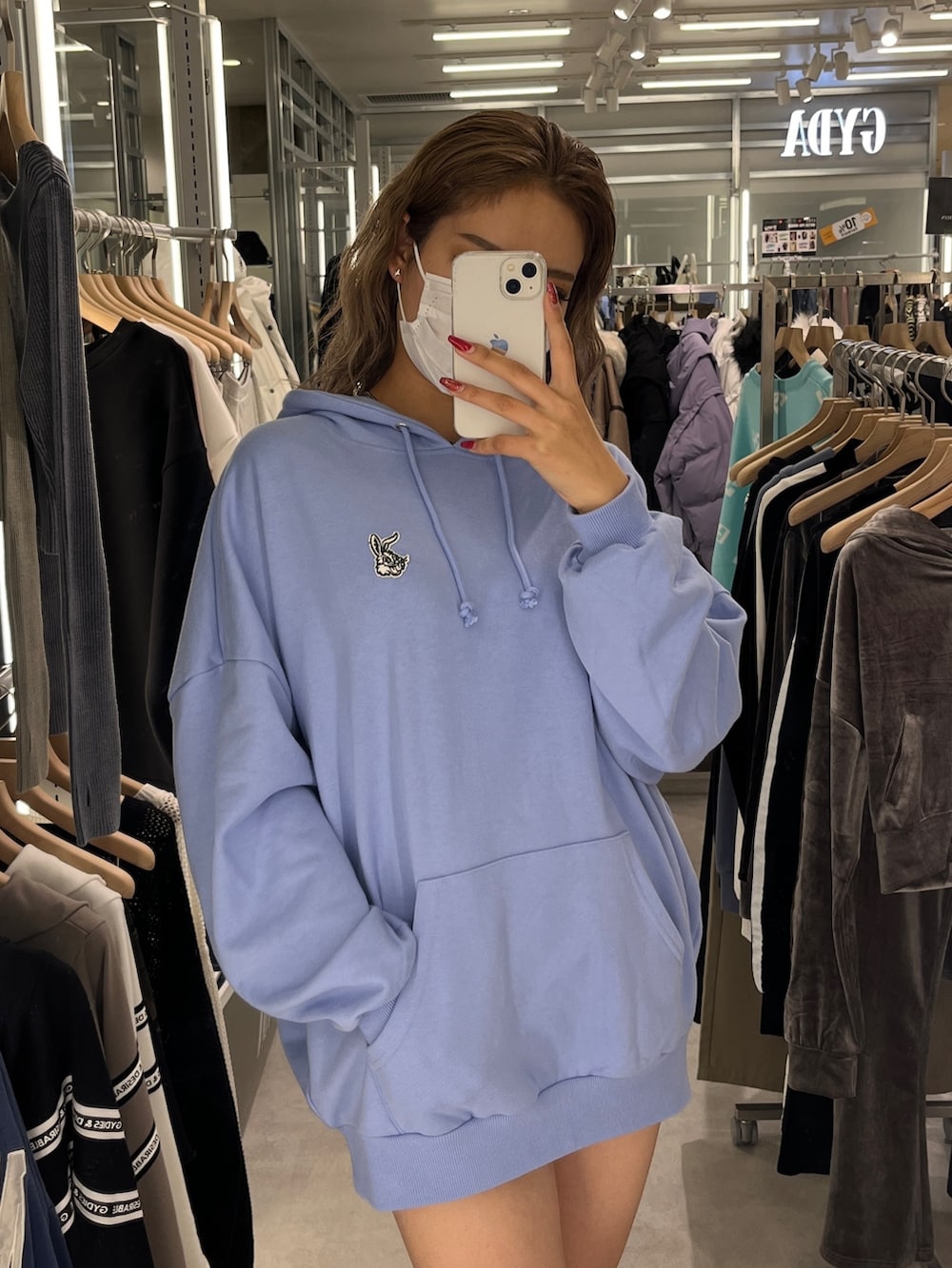 ブルー系のパーカー、シルバー系のハンドバッグ、ブラック系のブーツを着用したレディースの秋コーディネートの3枚目の写真