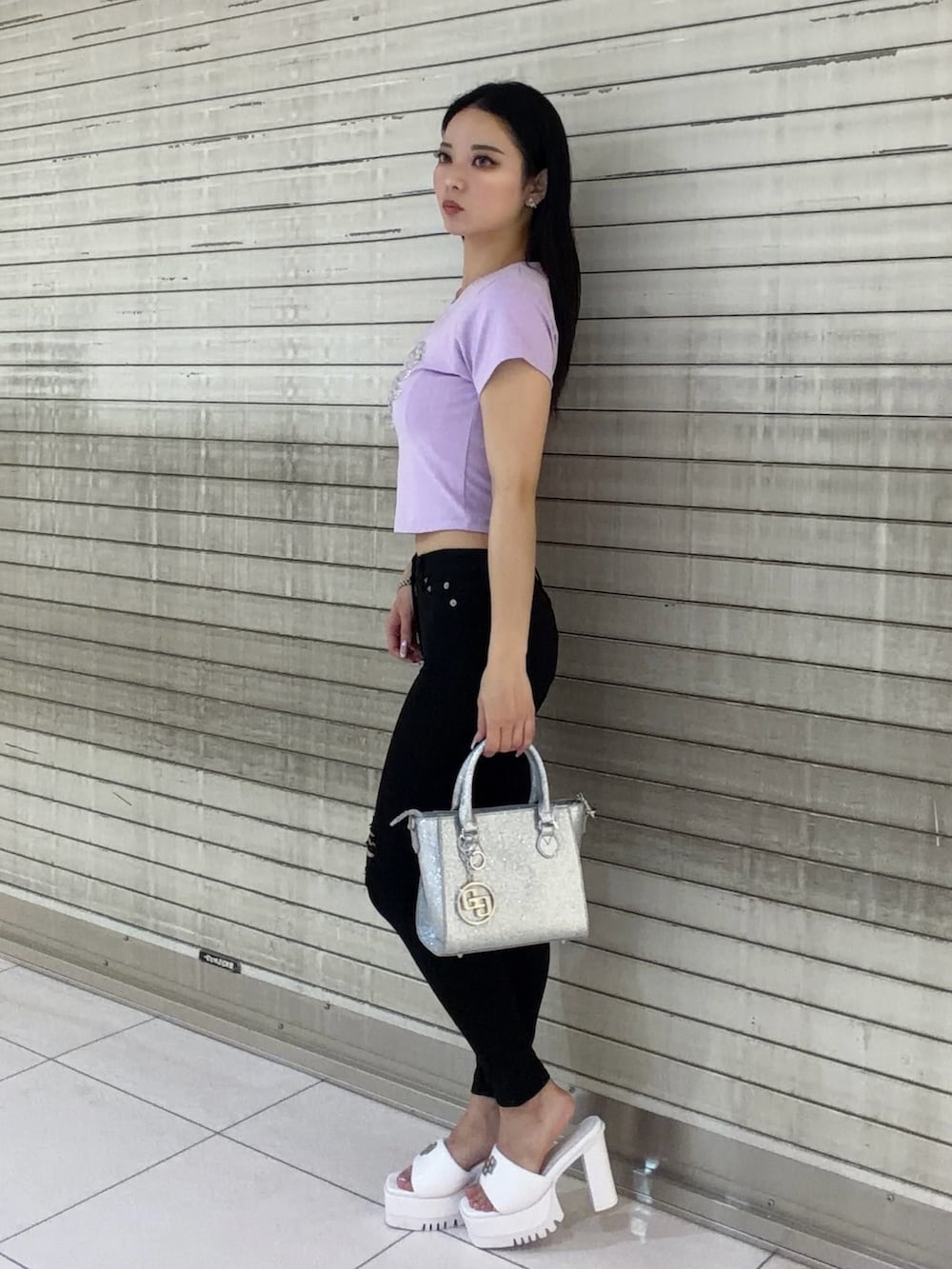 パープル系のTシャツ/カットソー、ブラック系のデニムパンツ、シルバー系のハンドバッグを着用したレディースの春コーディネートの3枚目の写真