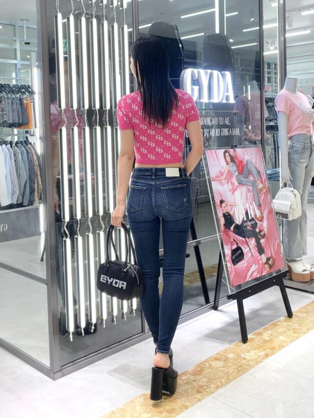 ブラック系のサンダル、ブルー系のデニムパンツ、ピンク系のニット/セーターを着用したレディースの夏コーディネートの4枚目の写真