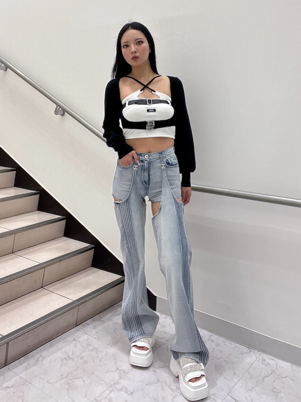 ホワイト系のキャミソール、ブラック系のカーディガン/ボレロ、ブルー系のデニムパンツを着用したレディースの春コーディネートの2枚目の写真