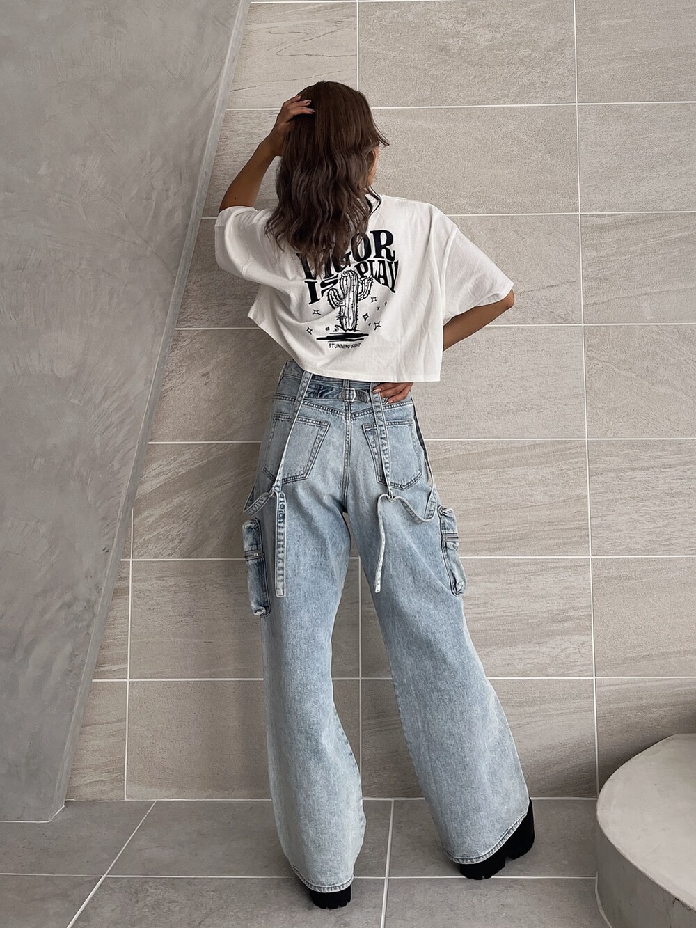 ホワイト系のTシャツ/カットソー、ブルー系のデニムパンツ、ブラック系のブーツを着用したレディースの夏コーディネートの4枚目の写真
