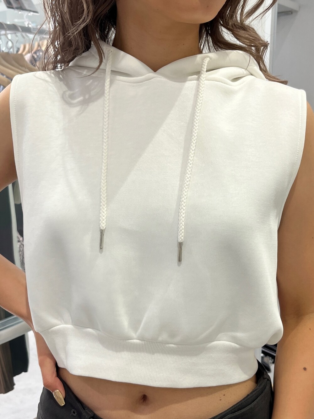 ホワイト系のパーカー、グレー系のスカート、ブラック系のブーツを着用したレディースの夏コーディネートの3枚目の写真