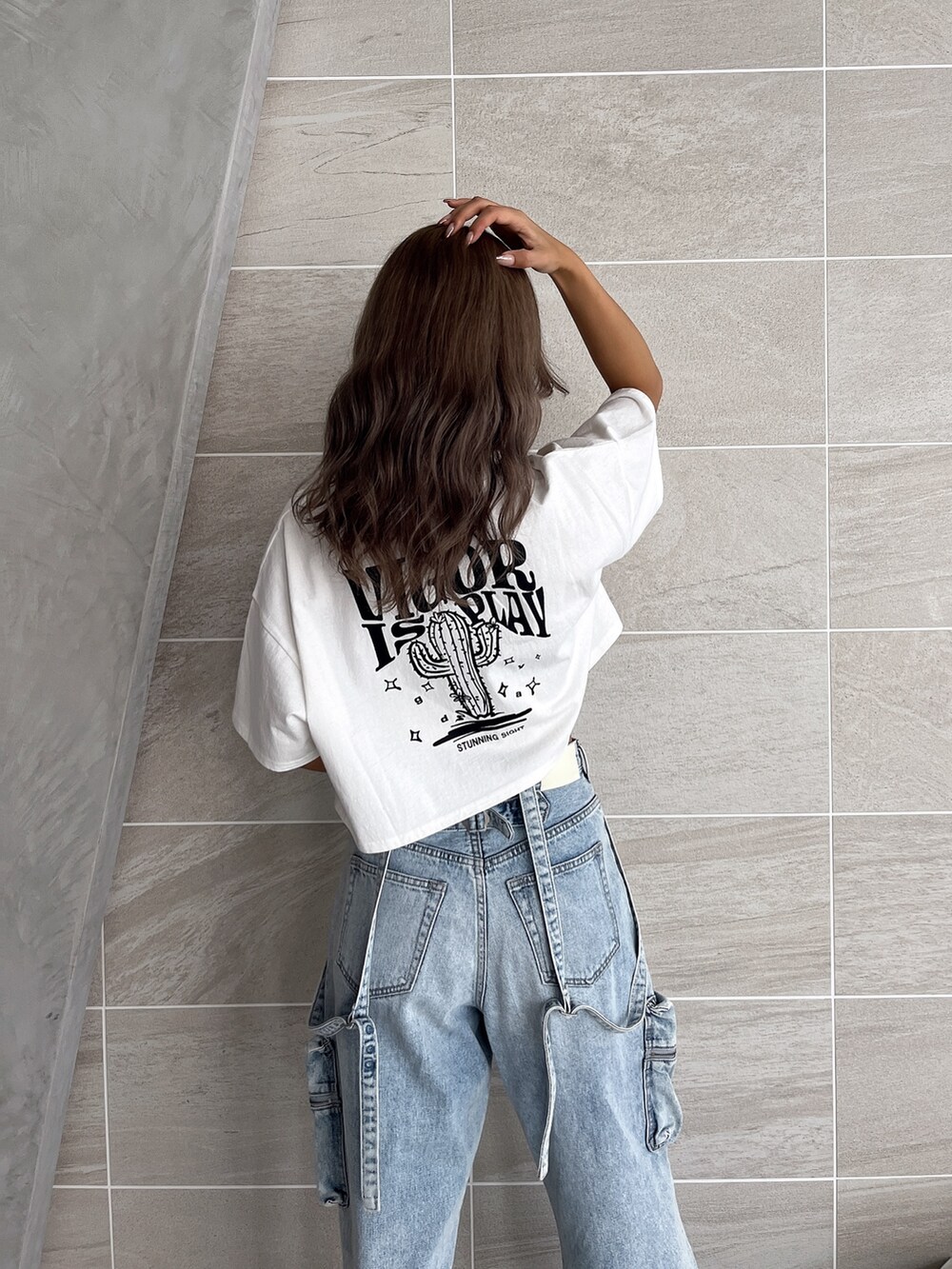 ホワイト系のTシャツ/カットソー、ブルー系のデニムパンツ、ブラック系のブーツを着用したレディースの夏コーディネートの8枚目の写真
