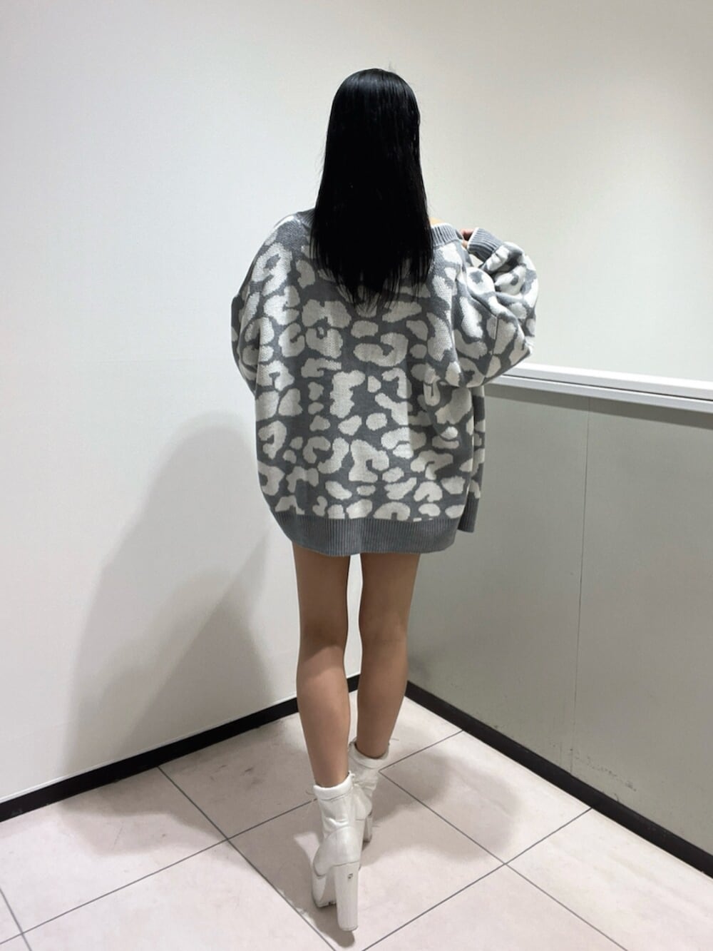 ブルー系のワンピース、ホワイト系のブーツ、グレー系のカーディガン/ボレロを着用したレディースの春コーディネートの4枚目の写真