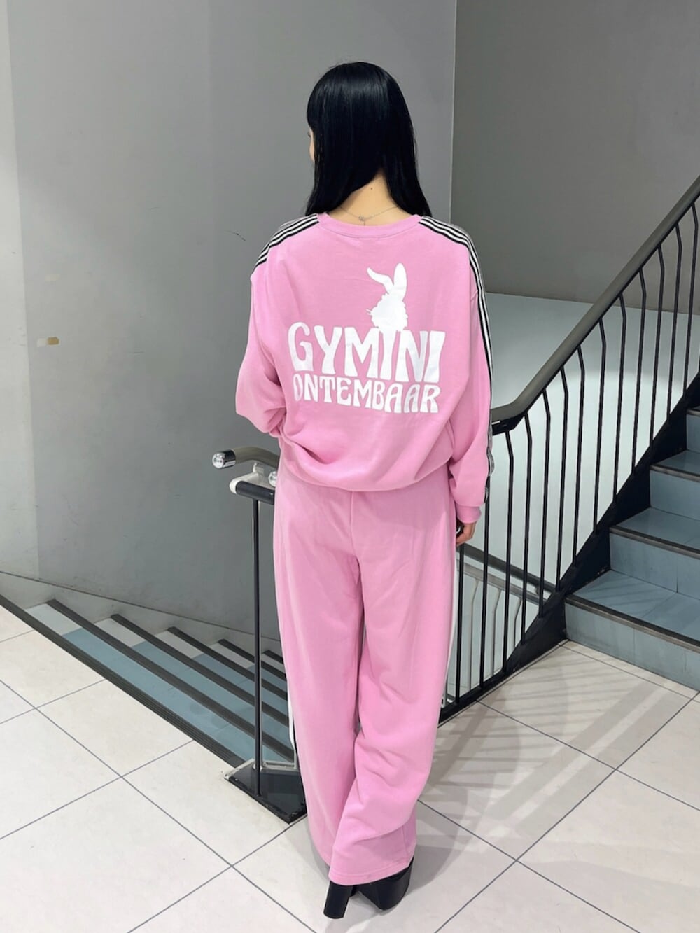 ブラック系のブーツ、ピンク系のスウェット、ピンク系のスウェットパンツを着用したレディースの冬コーディネートの5枚目の写真