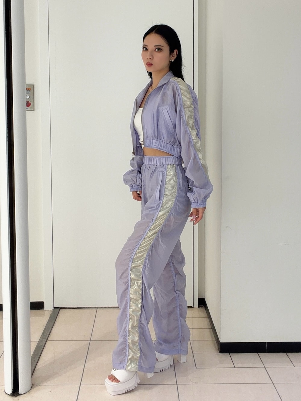 パープル系のブルゾン、パープル系のその他パンツ、ホワイト系のキャミソールを着用したレディースの春コーディネートの3枚目の写真