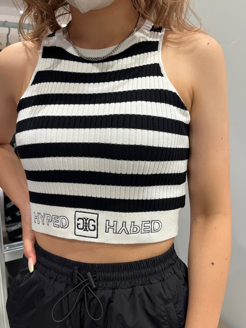 ブラック系のカーゴパンツ、ブラック系のパンプス、その他のタンクトップを着用したレディースの夏コーディネートの3枚目の写真