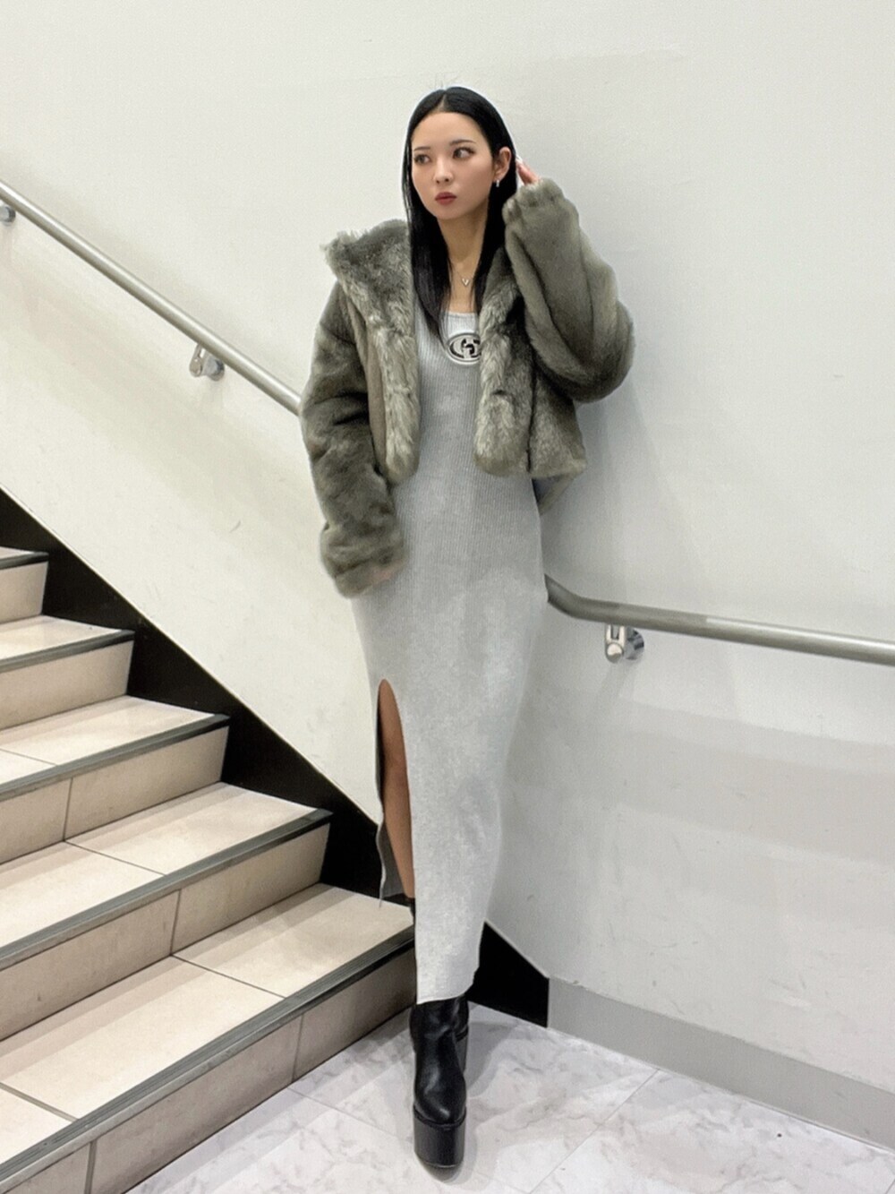 ブラック系のブーツ、グレー系のワンピースを着用したレディースの冬コーディネートの2枚目の写真