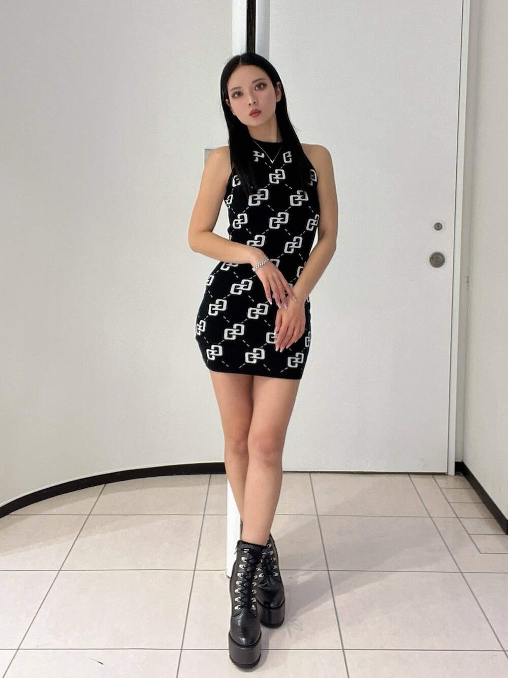 ブラック系のブーツ、ブラック系のワンピースを着用したレディースの春コーディネートの2枚目の写真