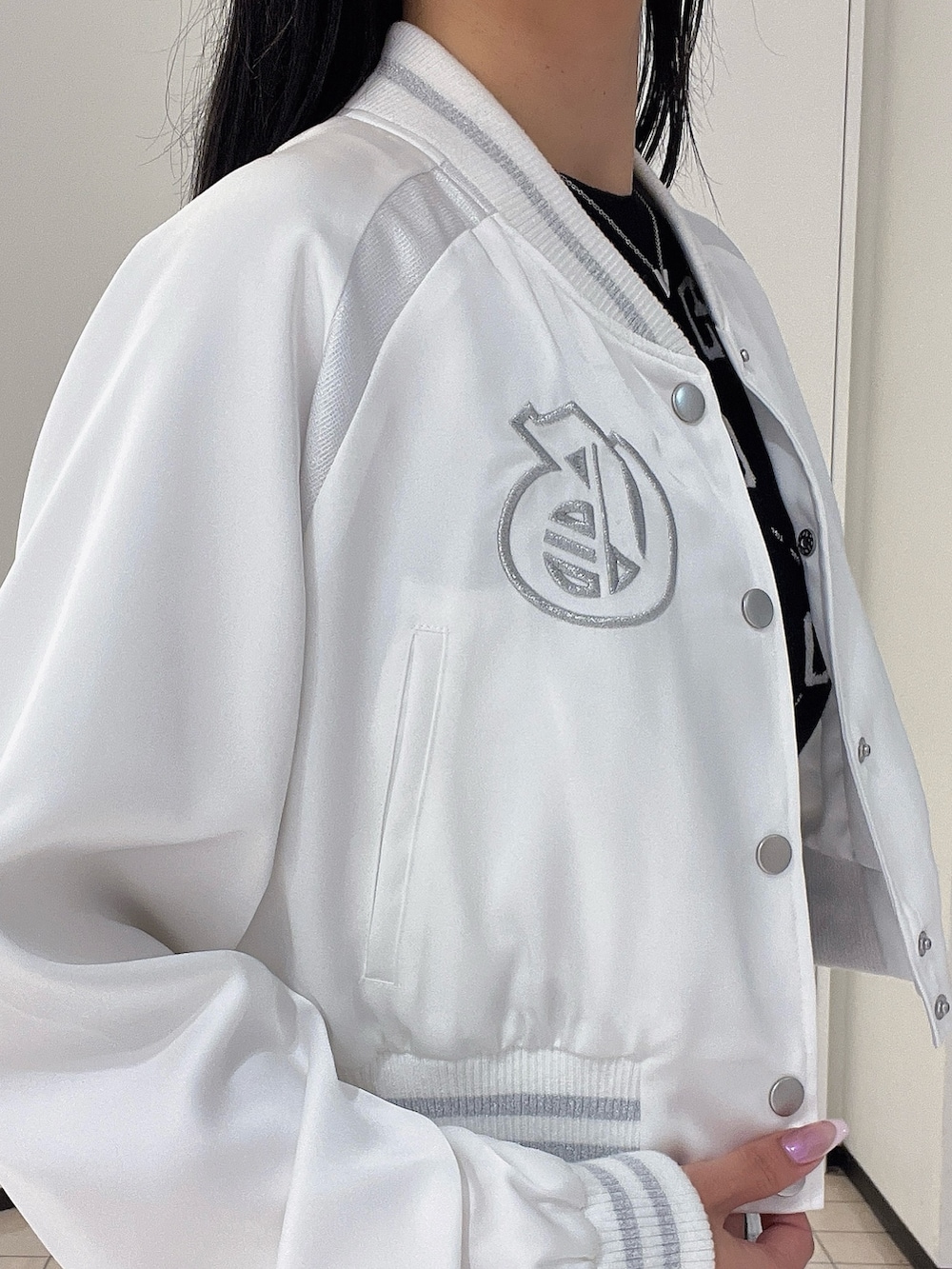 ブラック系のワンピース、ブラック系のブーツ、ホワイト系のブルゾンを着用したレディースの春コーディネートの7枚目の写真