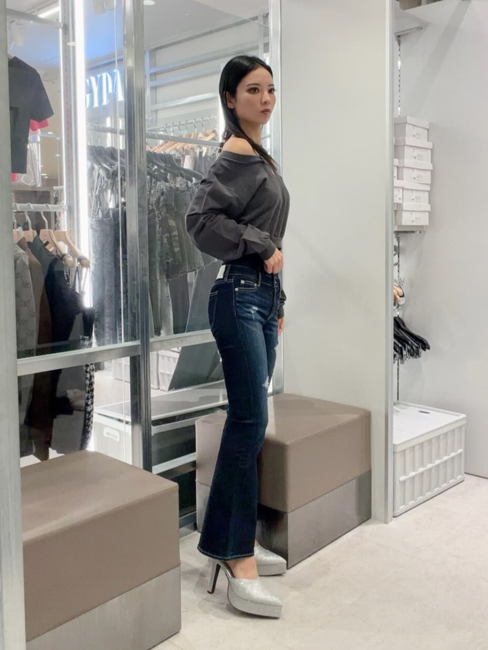 シルバー系のパンプス、ブルー系のデニムパンツ、グレー系のスウェットを着用したレディースの秋コーディネートの3枚目の写真