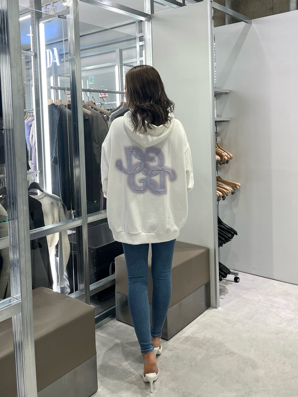 ホワイト系のパーカー、ブルー系のデニムパンツ、ホワイト系のパンプスを着用したレディースの冬コーディネートの2枚目の写真
