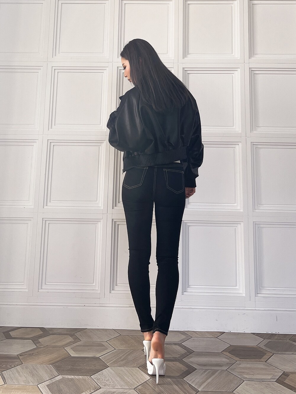 ホワイト系のニット/セーター、ブラック系のブルゾン、ブラック系のデニムパンツを着用したレディースの冬コーディネートの2枚目の写真