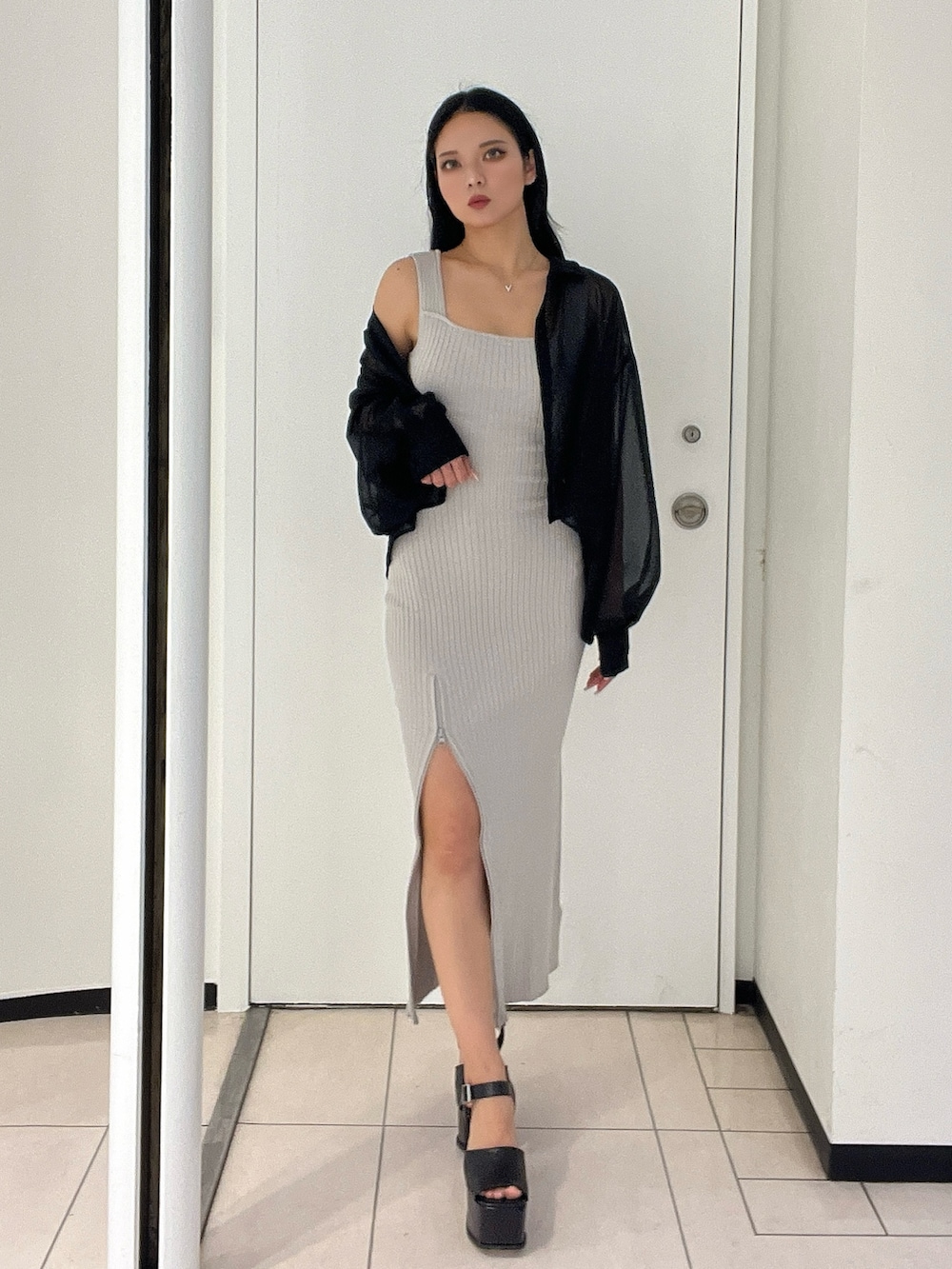 グレー系のワンピース、ブラック系のシャツ/ブラウス、ブラック系のサンダルを着用したレディースの春コーディネートの2枚目の写真