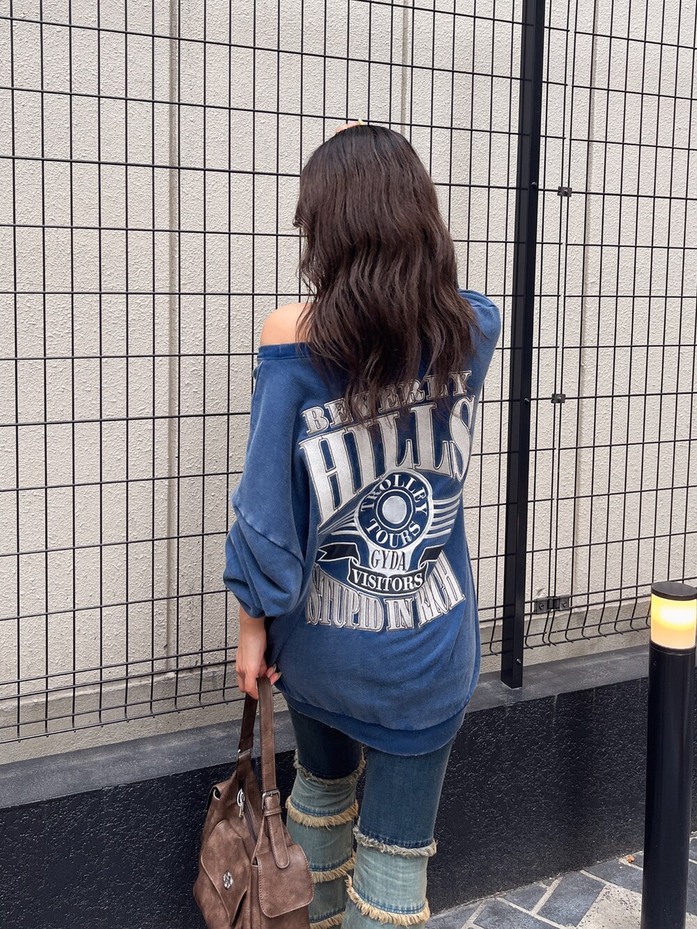 ブルー系のスウェット、ブルー系のデニムパンツ、ブラウン系のハンドバッグを着用したレディースの夏コーディネートの5枚目の写真