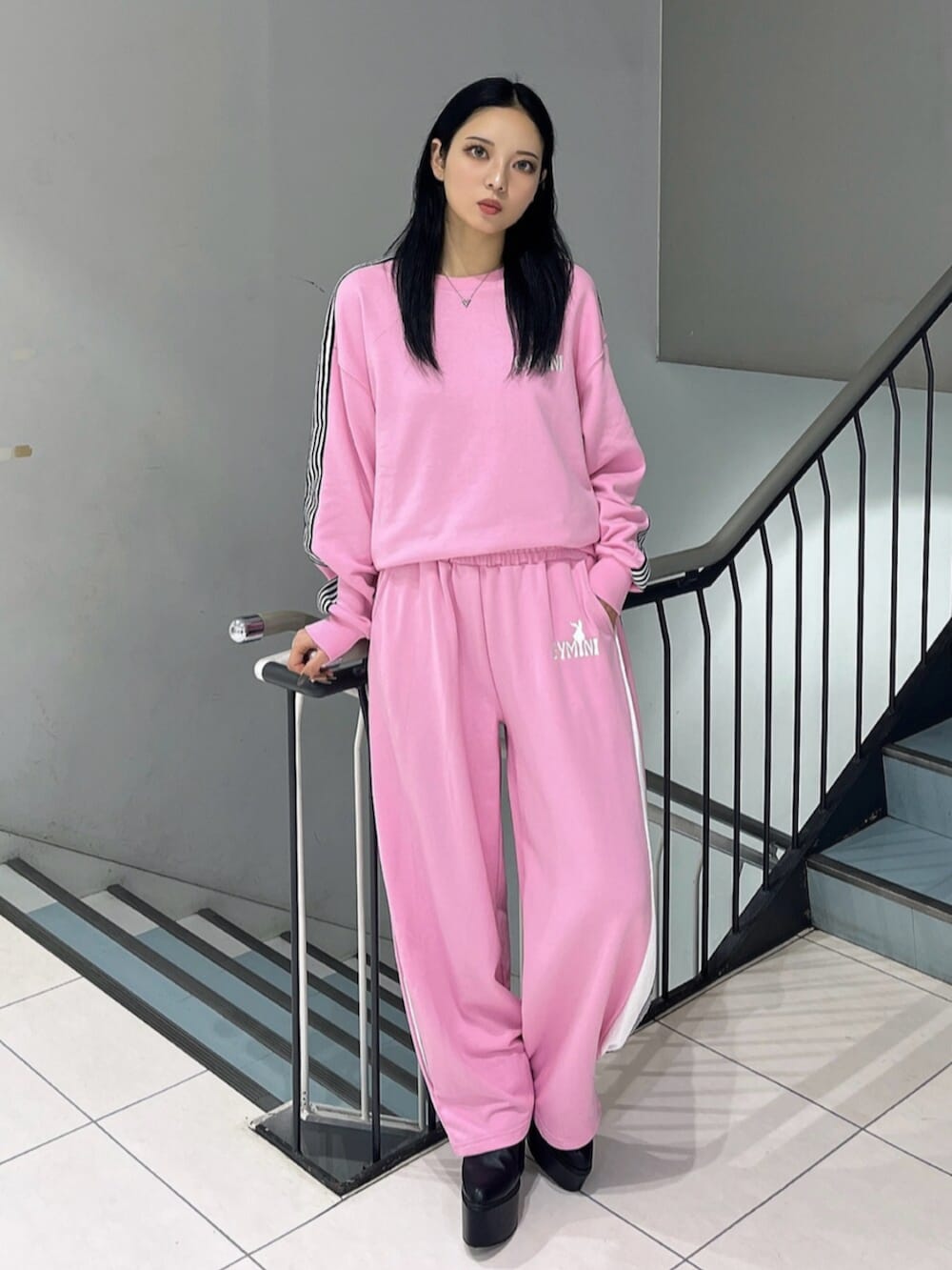 ブラック系のブーツ、ピンク系のスウェット、ピンク系のスウェットパンツを着用したレディースの冬コーディネートの3枚目の写真