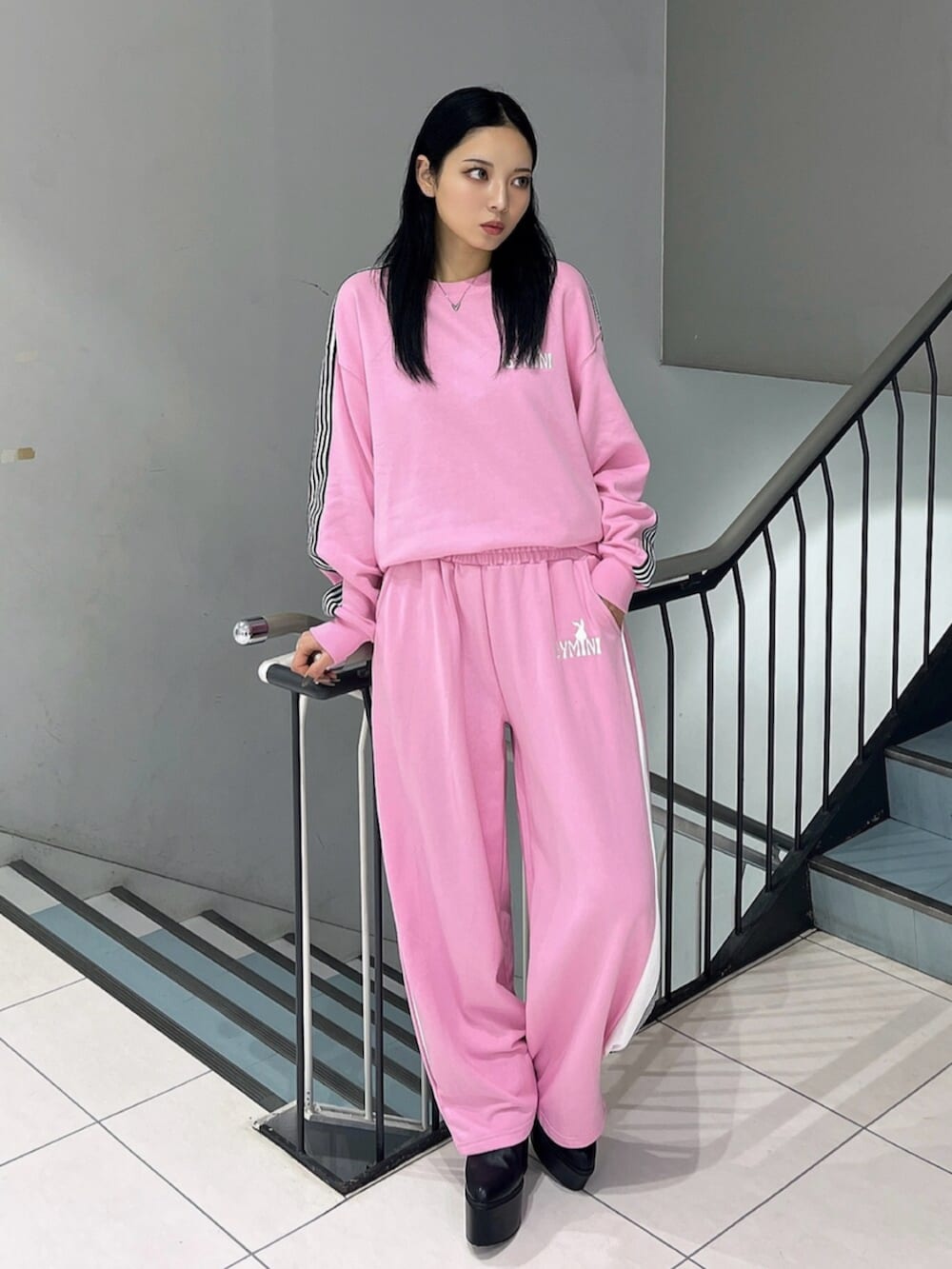 ブラック系のブーツ、ピンク系のスウェット、ピンク系のスウェットパンツを着用したレディースの冬コーディネートの2枚目の写真