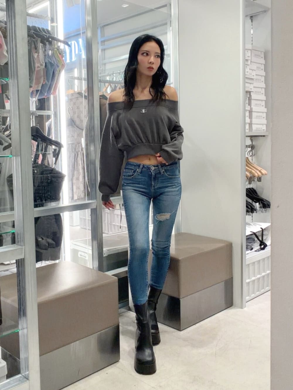 グレー系のTシャツ/カットソー、ブルー系のデニムパンツ、ブラック系のブーツを着用したレディースの秋コーディネートの2枚目の写真