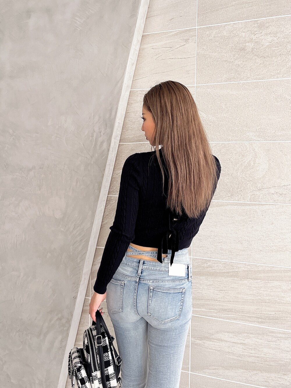 ブラック系のニット/セーター、ブルー系のデニムパンツ、その他のバックパック/リュックを着用したレディースの冬コーディネートの7枚目の写真