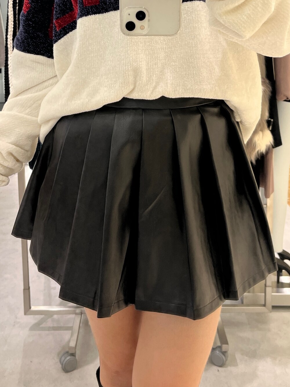 ホワイト系のニット/セーター、ブラック系のスカート、ブラック系のブーツを着用したレディースの秋コーディネートの4枚目の写真