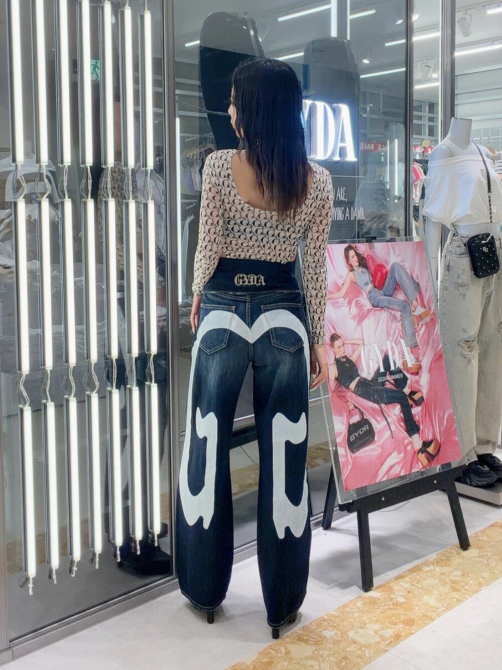 ブラック系のパンプス、ホワイト系のTシャツ/カットソー、ブルー系のデニムパンツを着用したレディースの夏コーディネートの4枚目の写真