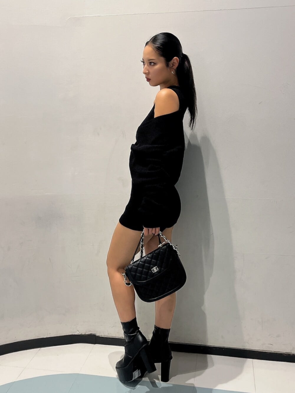 ブラック系のブーツ、ブラック系のハンドバッグ、ブラック系のつなぎ/オールインワンを着用したレディースの秋コーディネートの2枚目の写真