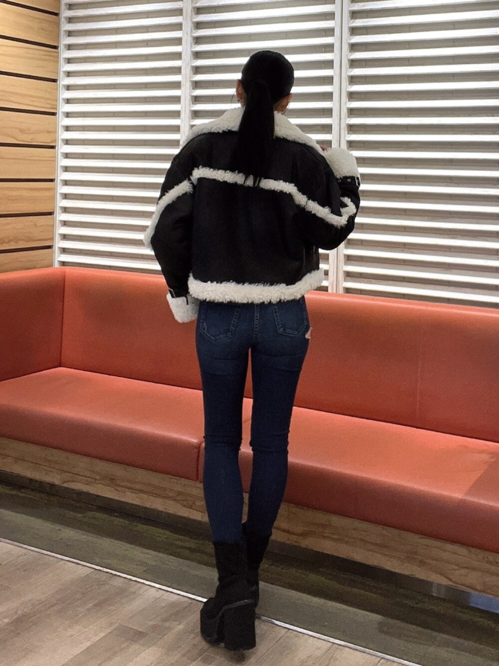 ホワイト系のニット/セーター、ブルー系のデニムパンツ、ブラック系のブーツを着用したレディースの秋コーディネートの4枚目の写真