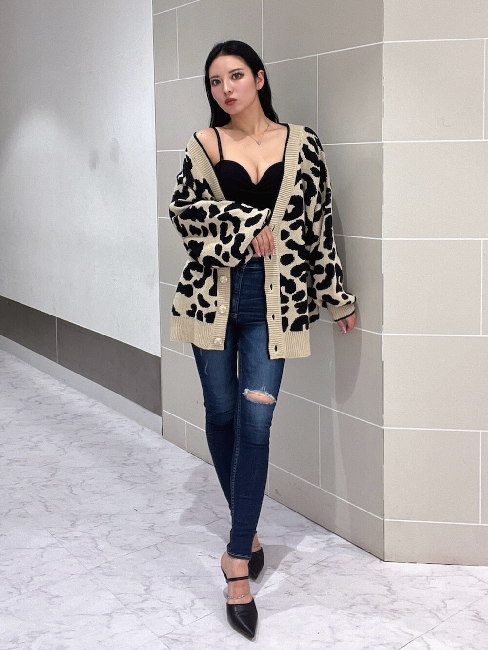 ブラック系のキャミソール、ブラック系のパンプス、ブルー系のデニムパンツを着用したレディースの春コーディネートの3枚目の写真