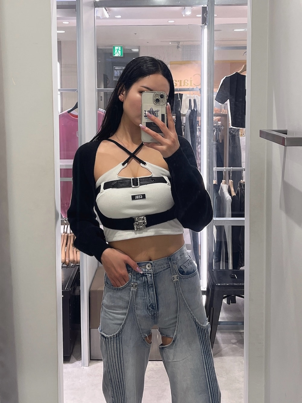 ホワイト系のキャミソール、ブラック系のカーディガン/ボレロ、ブルー系のデニムパンツを着用したレディースの春コーディネートの6枚目の写真