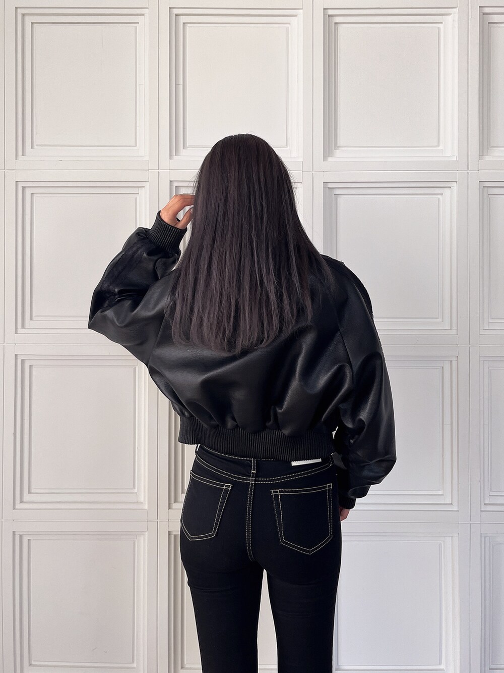 ホワイト系のニット/セーター、ブラック系のブルゾン、ブラック系のデニムパンツを着用したレディースの冬コーディネートの4枚目の写真