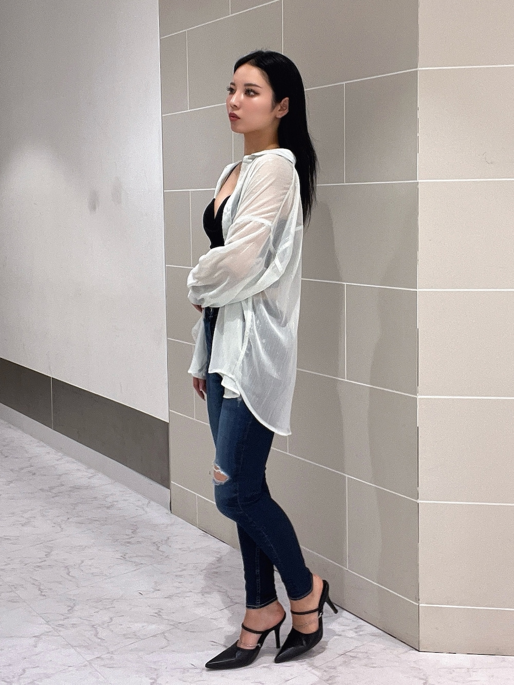 ブラック系のキャミソール、ブルー系のデニムパンツ、ブラック系のパンプスを着用したレディースの春コーディネートの4枚目の写真