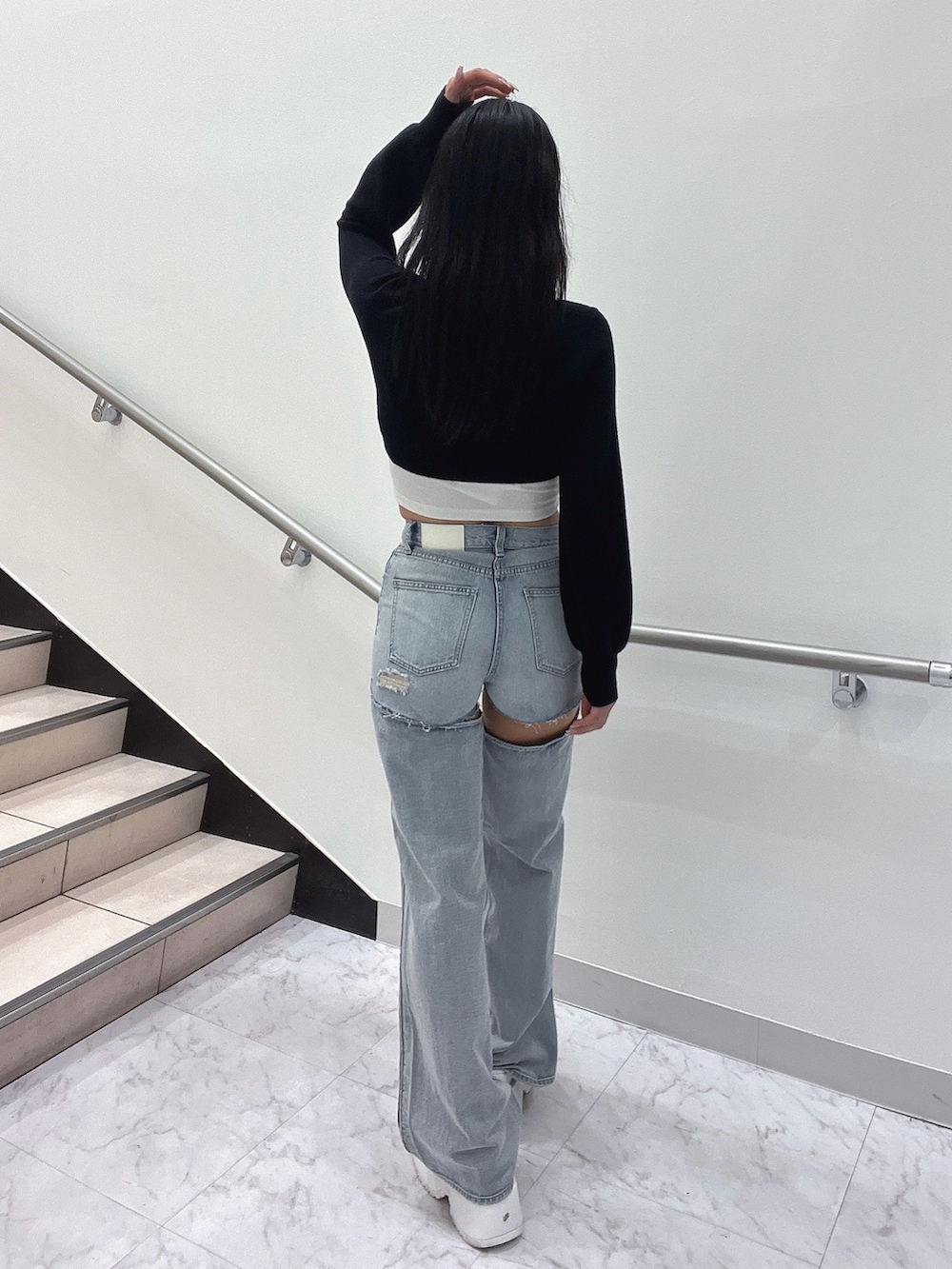 ホワイト系のキャミソール、ブラック系のカーディガン/ボレロ、ブルー系のデニムパンツを着用したレディースの春コーディネートの4枚目の写真