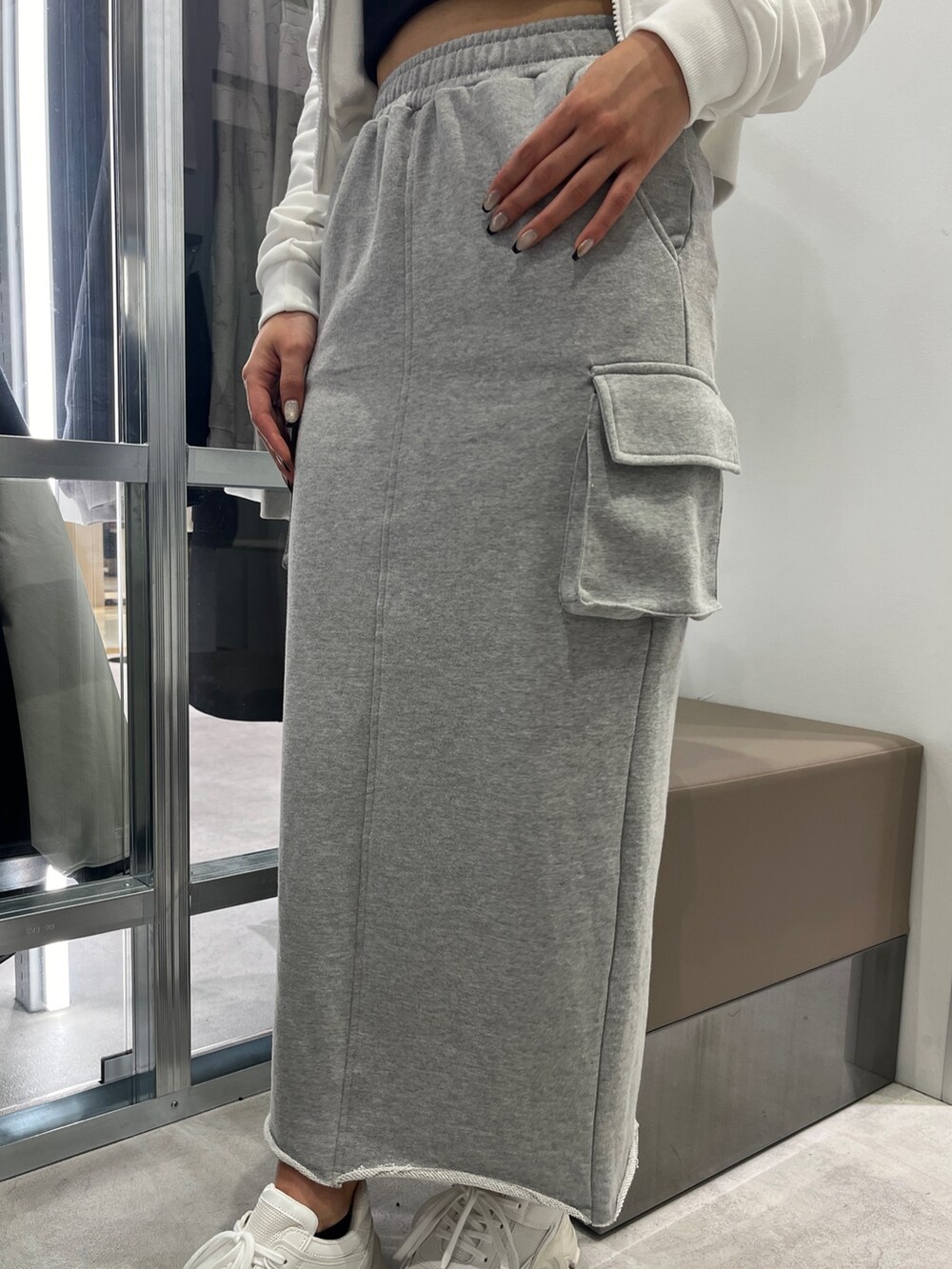 ホワイト系のパーカー、ブラック系のキャミソール、グレー系のスカートを着用したレディースの冬コーディネートの4枚目の写真