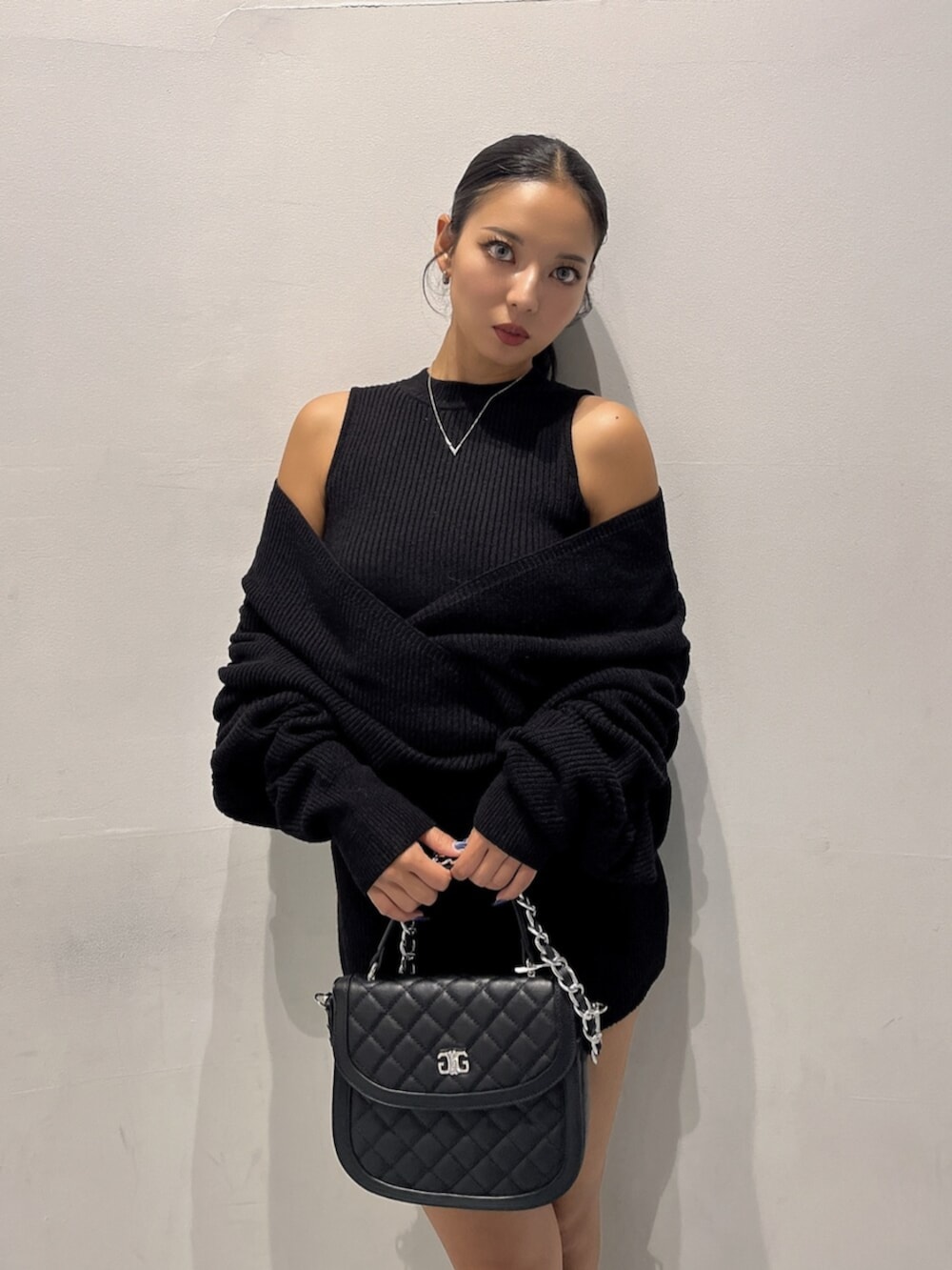 ブラック系のブーツ、ブラック系のハンドバッグ、ブラック系のつなぎ/オールインワンを着用したレディースの秋コーディネートの5枚目の写真