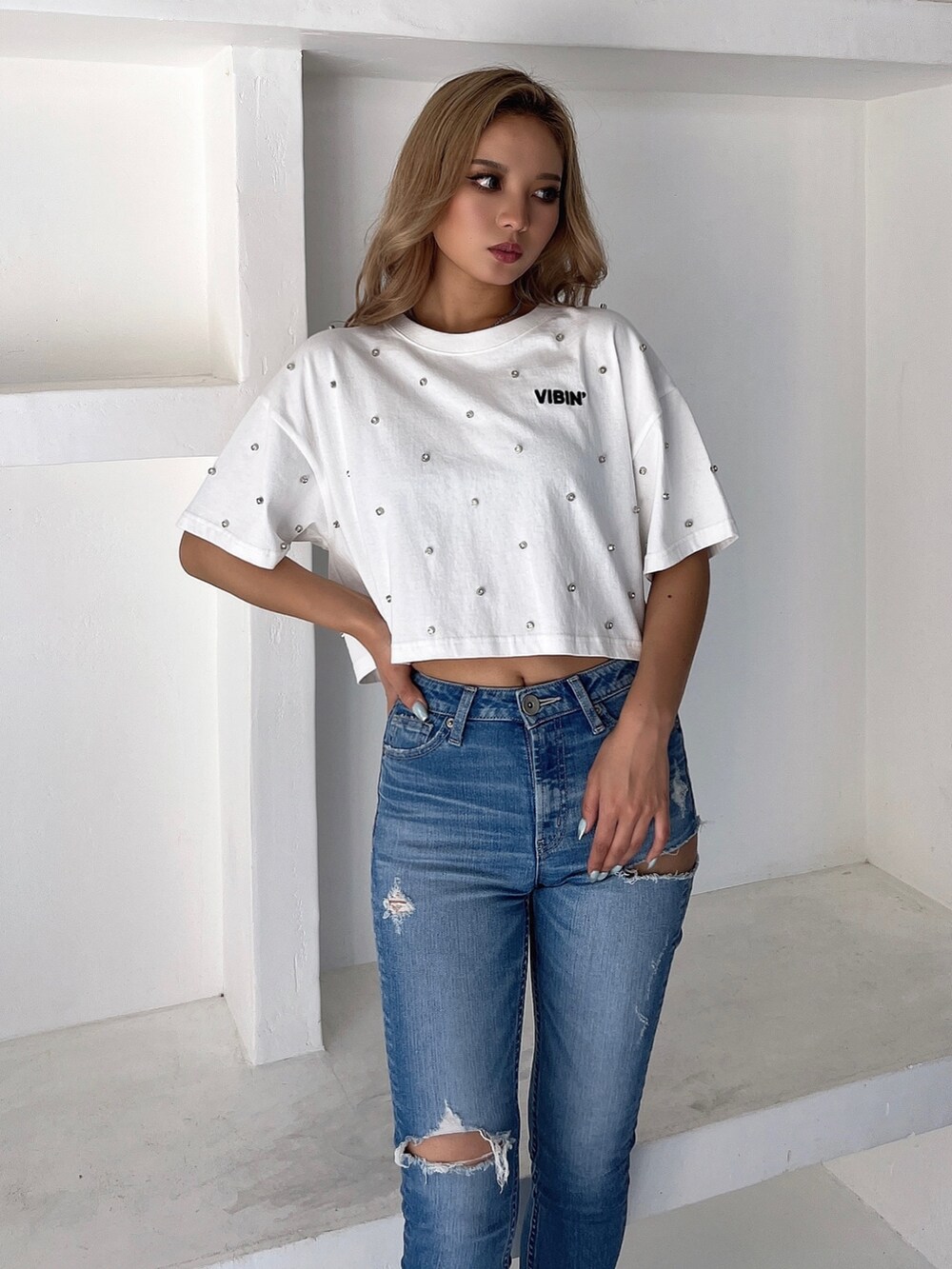 ホワイト系のTシャツ/カットソー、ブルー系のデニムパンツ、ブラック系のサンダルを着用したレディースの春コーディネートの3枚目の写真