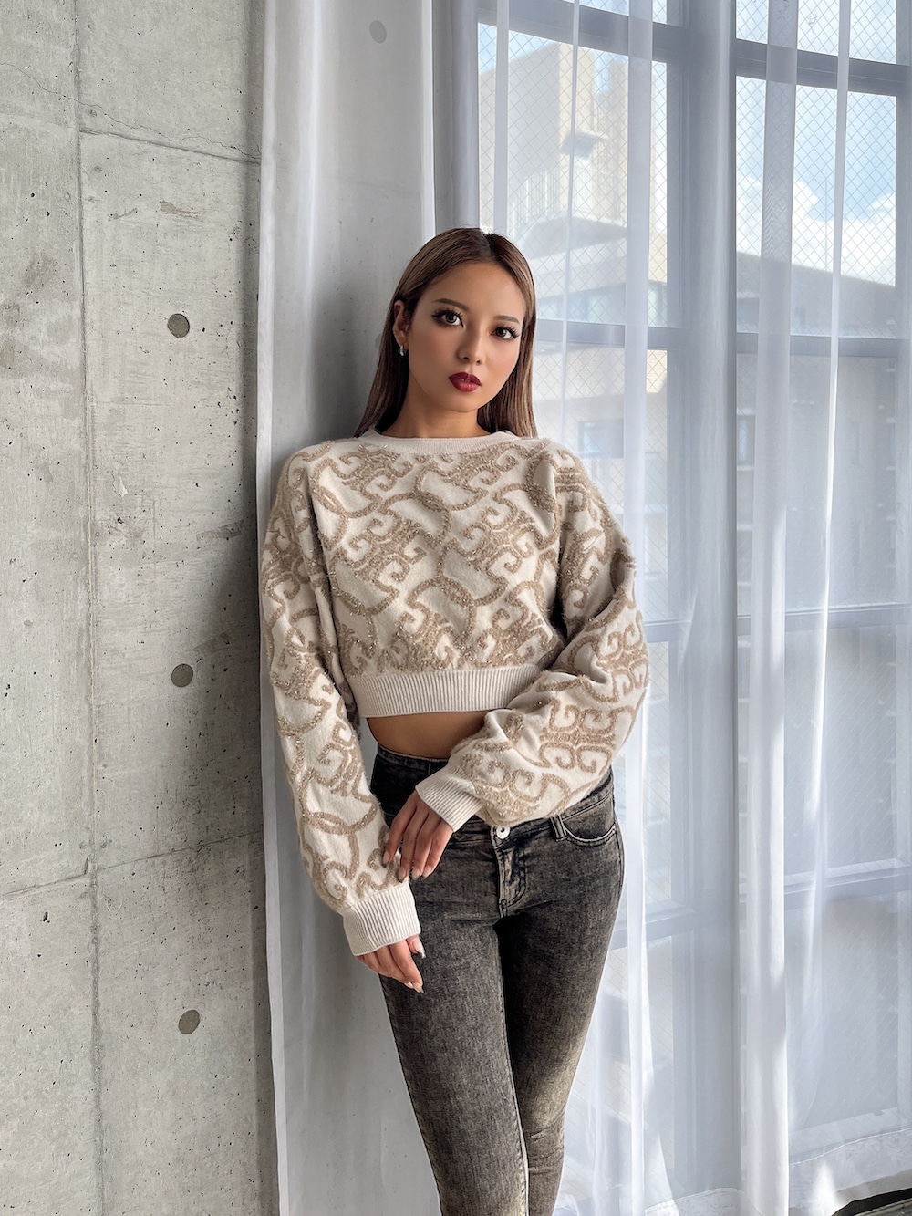 ホワイト系のニット/セーター、ブラック系のデニムパンツ、ホワイト系のブーツを着用したレディースの秋コーディネートの5枚目の写真